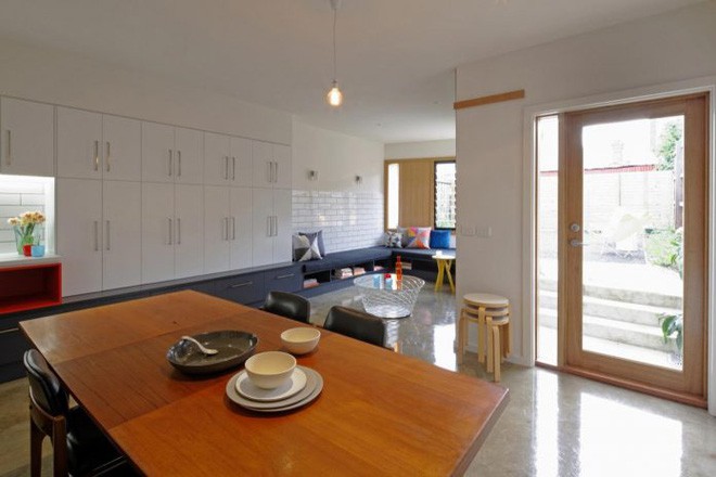 Đi dọc vào bên trong là hệ thống tủ đựng đồ sát tường tiện lợi, phía đối diện nhường cho những ô cửa sổ. Thêm bộ bàn ghế xinh yêu, đẹp mắt bằng gỗ pha da tiện lợi và hiện đại.