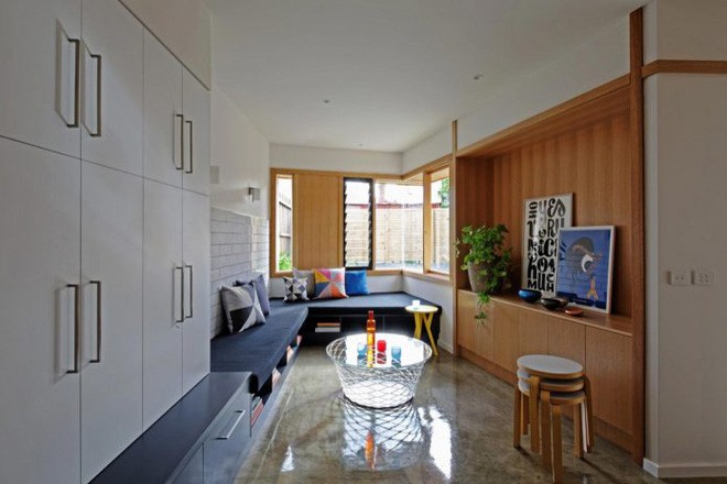 Phía dưới ghế sofa gắn tường được thiết kế các ngăn lưu trữ sách.