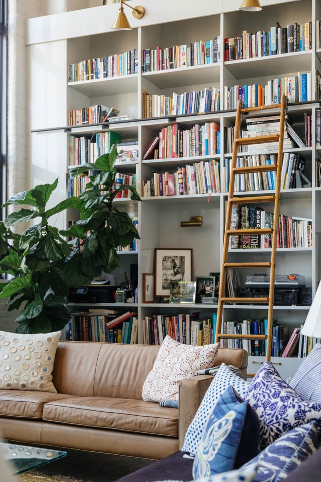 Góc phòng tiếp khách với điểm nhấn từ hệ thống kệ sách và thang đặt linh hoạt, tiện lợi cho việc lấy sách.