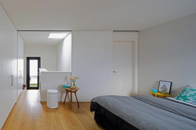 Tầng 2 là không gian phòng ngủ, gọn gàng xinh yêu với hệ thống tủ đồ âm tường. Nội thất đơn giản với tap đầu giường, giường ngủ chọn ga màu ghi xám nổi bật.