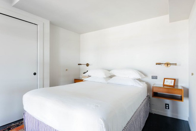 Giường ngủ được sắp xếp gọn gàng ở bên trong cùng của căn phòng.