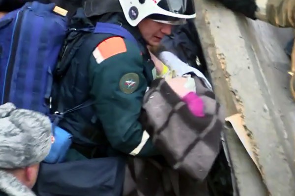 Nh&acirc;n vi&ecirc;n cứu hộ đưa b&eacute; trai 10 th&aacute;ng tuổi ra xe cấp cứu gần nhất. Ảnh: RT