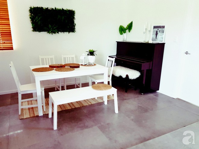 Không gian ăn uống với bàn ghế màu trắng nổi bật trên nền sàn và thảm trải sàn màu tối.