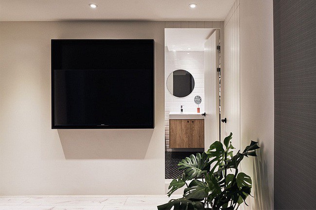 Một chiếc ti vi cỡ lớn được gắn lên tường ngay lối đi vào phòng tắm.