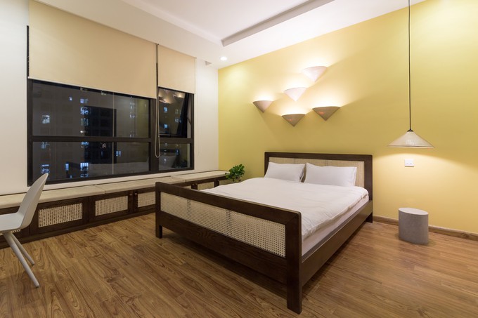 Phòng ngủ chính được các kiến trúc sư sử dụng nón lá cắt đôi làm đèn ngủ. Giường và giá kệ, ngăn tủ cũng được làm từ gỗ bọc mây rất hài hoà dễ chịu.