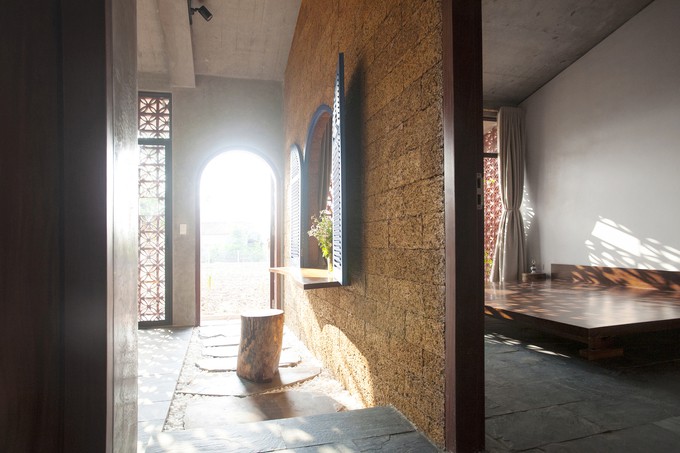 Bức tường phòng ngủ được làm từ đá tổ ong - một vật liệu tự nhiên mang từ Sơn Tây về. Dù đá tổ ong ít được sử dụng trong nội thất vì độ nhám và khó lắp chính xác, các thợ thủ công đá địa phương đã tinh chỉnh giúp tạo ra một bức tường với cửa sổ hình vòm có thể kết nối phòng ngủ với phòng khách.