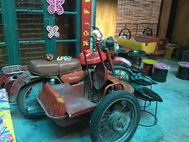 Chiếc xe gắn máy Milk của Nga đã bị hư hỏng được chủ quán tận dụng vừa làm bàn ngồi vừa làm đồ trang trí