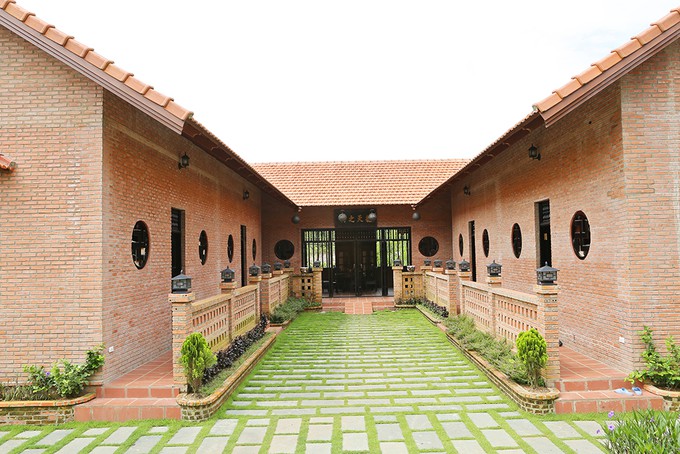 Diễn viên trồng cỏ giữa lối đi lót bằng đá, tạo cảm giác xanh mát.