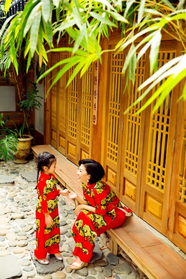 Hai mẹ con Mai Phương vô tư cười đùa, nói chuyện với nhau khi diện trang phục truyền thống in hoạ tiết chú heo.