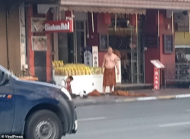 Nạn nh&acirc;n gục xuống đường (tr&aacute;i). Nghi phạm vẫn cầm dao tr&ecirc;n tay (cởi trần, b&ecirc;n phải)