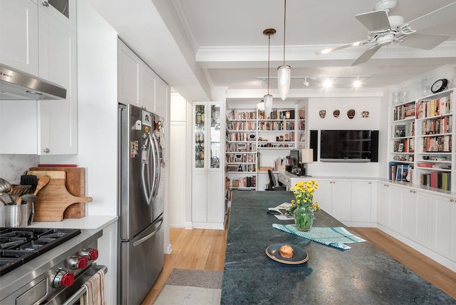 Ti vi đặt gần đảo bếp được nhấc lên gắn tường tiện lợi và mở rộng tối đa diện tích cho không gian sống.