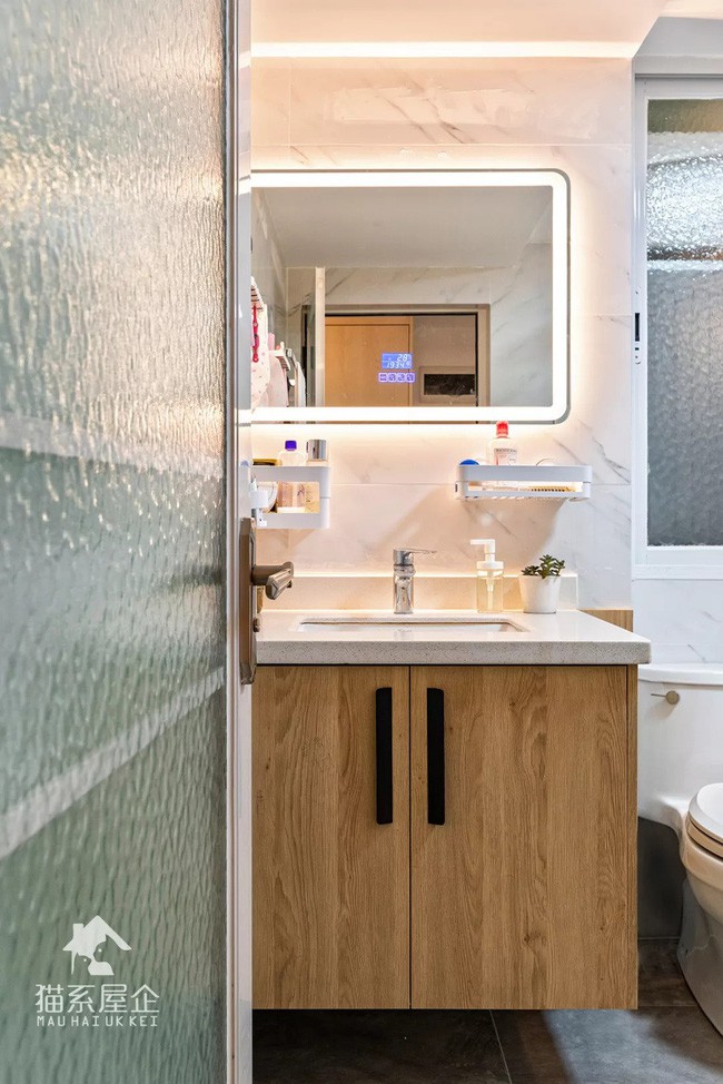 Phòng tắm lấy thiết kế hiện đại làm chủ với các thiết kế kệ tủ gỗ và gương ăn gian diện tích.