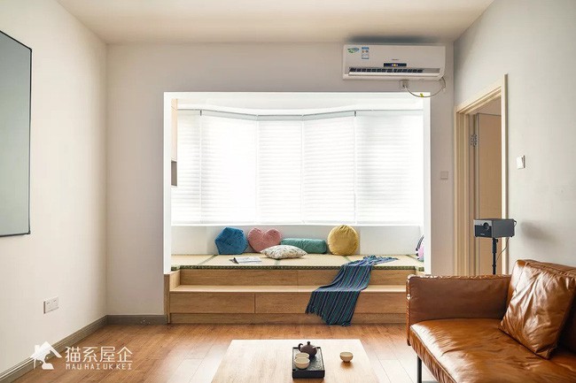 Phòng khách với ghế ngồi bên cửa sổ gây cảm giác thị giác tức thì nhờ gam màu nâu trầm ấm nóng.