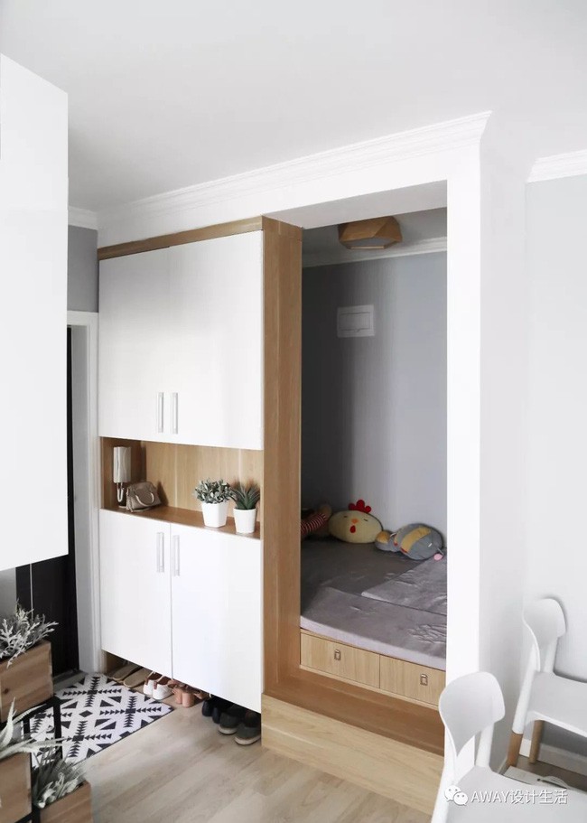 Bên cạnh lối vào còn có kệ kim loại sơn màu đen giúp những chậu cây gỗ trở thành điểm nhấn xanh tươi, xinh xắn cho căn hộ. Căn phòng bên trong nhỏ xinh, đa năng.