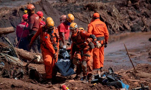 Nhân viên cứu hộ đưa thi thể nạn nhân vụ vỡ đập ra ngoài. Ảnh: Reuters.