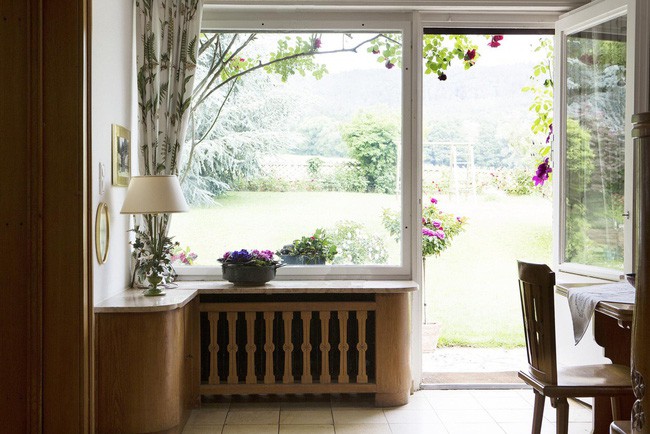 Nhìn từ bên trong ngôi nhà cũng có thể thấy được vẻ đẹp rực rỡ của hoa lá bên ngoài, xa xa là bãi cỏ rộng rãi.