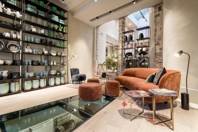 Góc phòng khách phụ toát lên vẻ đẹp sang trọng và không kém phần ấn tượng với hệ thống kệ đựng đồ bằng kim loại gắn cố định lên tường. Trên kệ được đặt vô số đồ gốm sứ, thủy tinh, những vật dụng vừa để trang trí nhà vừa giúp những góc nhỏ thêm ấn tượng. Bộ sofa màu cam đất đẹp như mơ từ kiểu dáng đến màu sắc tạo nên đường nét thanh tú và mềm mại cho không gian.