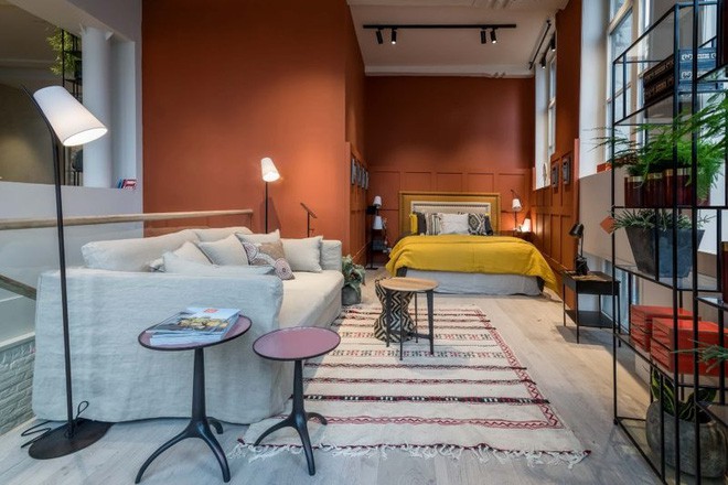 Bên cạnh phòng khách là khu vực nghỉ ngơi. Không gian phòng ngủ được thiết kế hai gam màu đối lập là cam đất và trắng be. Khu vực màu cam đất được tạo với hệ thống tủ âm tường và giường ngủ. Khu vực màu trắng be để bài trí sofa và bàn trà tạo nên căn phòng đầy đủ chức năng cùng vẻ đẹp hiện đại khó cưỡng.