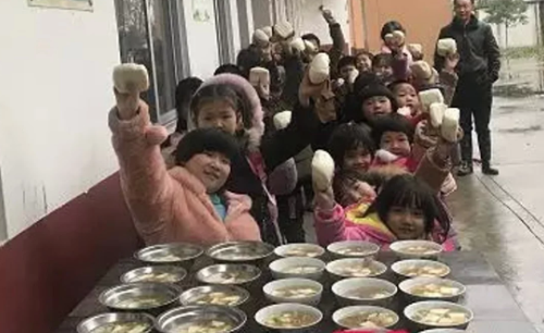 Học sinh vui vẻ khi nhận được bữa ăn do thầy tự tay chuẩn bị. Ảnh: SCMP