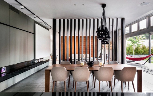 Những thanh gỗ làm vách ngăn của ngôi nhà đương đại này được nhuộm với tông màu đen huyền bí. Mỗi thanh gỗ có thể được quay để đóng hoàn toàn không gian hoặc mở nó như hình.