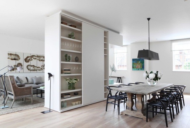 Một tủ đặt ở trung tâm nhà với diện tích khá lớn có thể lưu trữ dao kéo và đồ sứ cho phòng ăn, giữ sách và tivi ở phía phòng khách.