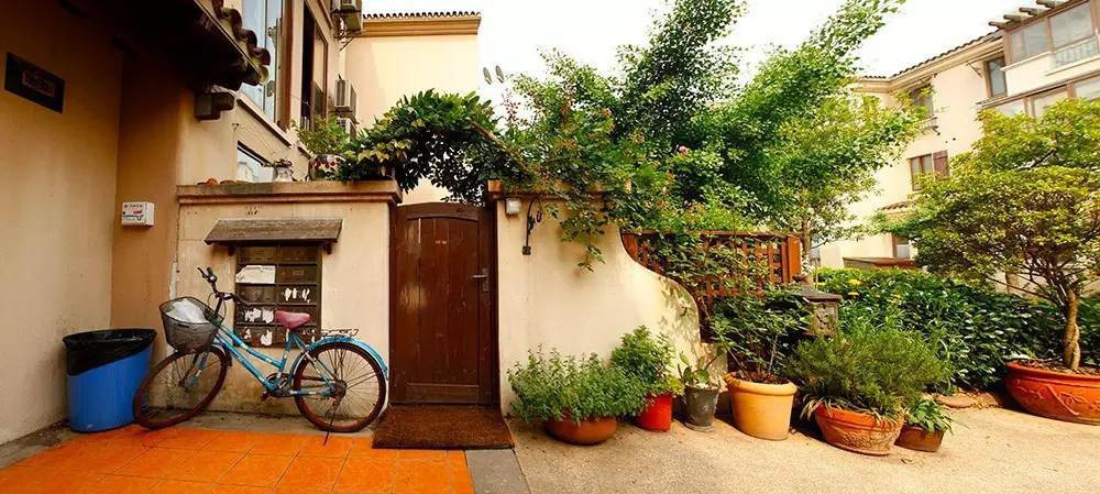 Góc sân dẫn vào khu vườn phía bên kia cánh cổng gỗ.