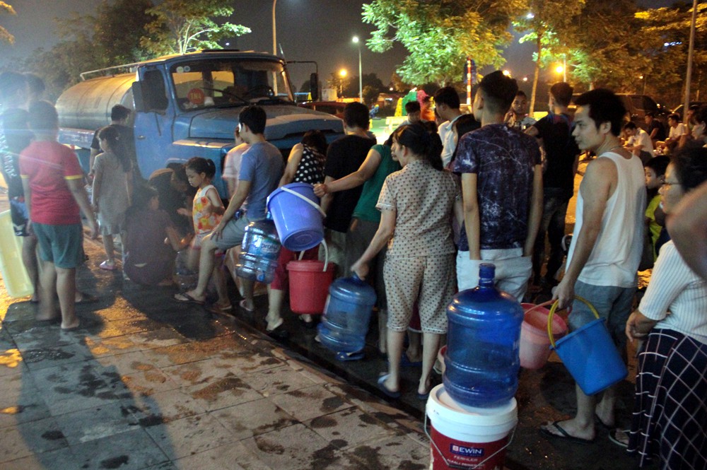 Hà Nội: Gần 0h đêm, người dân vẫn xếp hàng dài như thời bao cấp xách từng can nước - Ảnh 1. Hà Nội: Gần 0h đêm, người dân vẫn xếp hàng dài như thời bao cấp xách từng can nước - Ảnh 1.