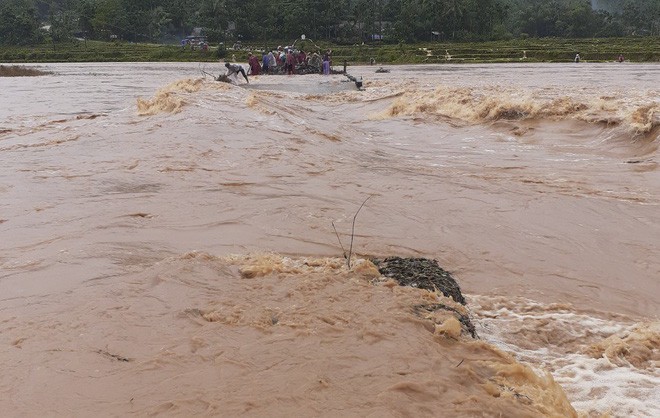 Lũ lớn đánh sập cầu độc đạo, dân lấy cây bắc cầu tạm qua sông - Ảnh 1. Lũ lớn đánh sập cầu độc đạo, dân lấy cây bắc cầu tạm qua sông - Ảnh 1.