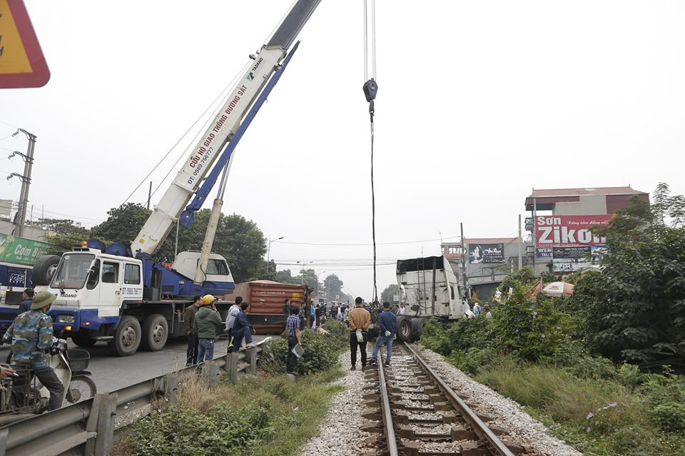 Hà Nội: Xe container mắc kẹt, tài xế cố vẫy tàu dừng lại nhưng quá muộn - Ảnh 1. Hà Nội: Xe container mắc kẹt, tài xế cố vẫy tàu dừng lại nhưng quá muộn - Ảnh 1.