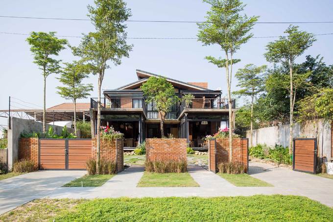 Ngôi nhà hai trong một được xây dựng trên miếng đất rộng 380 m2, nằm dưới chân núi Sơn Trà, Đà Nẵng. Nhà xây hai tầng, có tổng diện tích sàn 280 m2.