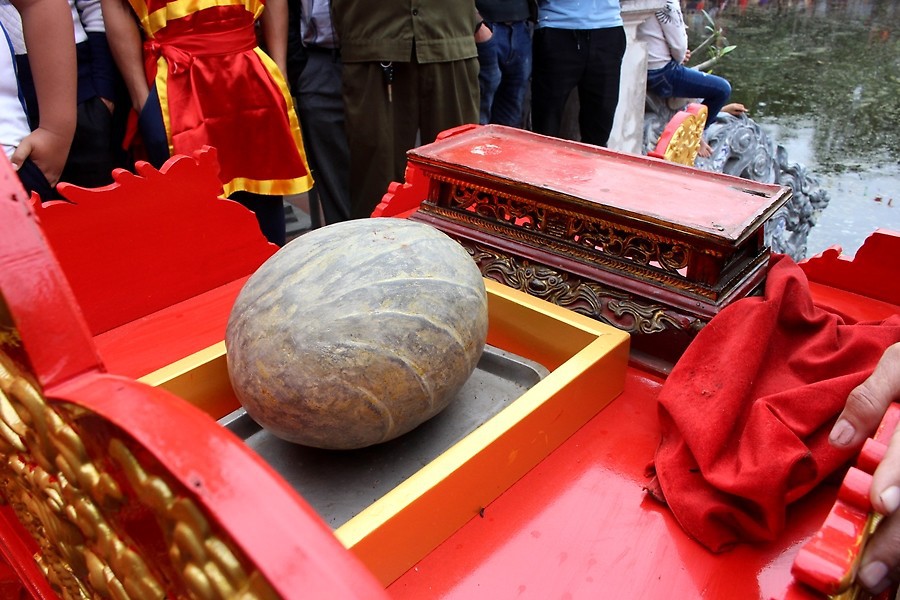 Hòn đá thiêng có hình bầu nặng 20kg được dân làng rước đến đình tổ chức thi chạy cùng đá. Ảnh: BHP