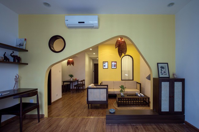 Quá trình cải tạo được bắt đầu từ việc loại bỏ những bức tường ngăn cách cứng nhắc để tạo sự liên kết, kết nối cho căn hộ có diện tích vừa phải. Chất Việt xưa được thể hiện rất rõ qua những mảng tường vàng nhạt và những món đồ trang trí rất khơi gợi về cảm giác ngày xưa ơi như bộ đèn bằng đó bắt cá, bộ bàn ghế phòng khách đan xen giữa gỗ và mây hay những bức tranh Đông Hồ rực rỡ.
