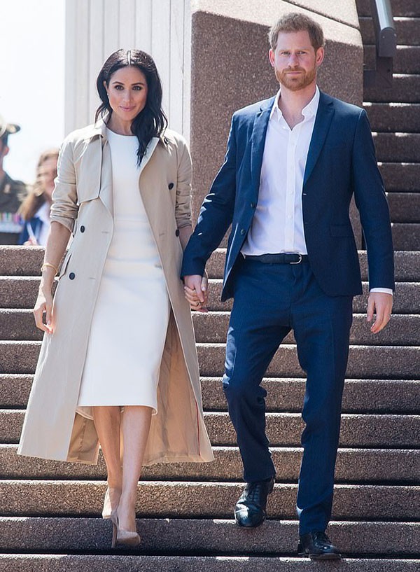 Vợ chồng Harry - Meghan nắm tay nhau trước khi gặp người hâm mộ ở Sydney trong chuyến công du hồi tháng 10/2018. Ảnh: AP.