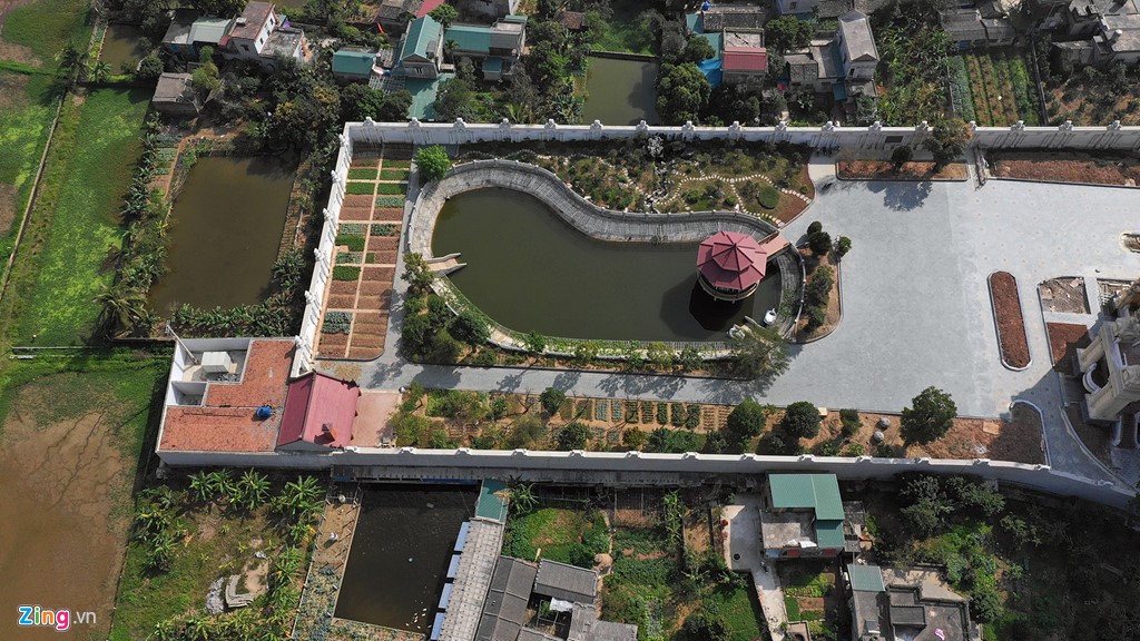 Phía sau là hồ nước lớn, xung quanh như một công viên, bên ngoài có tường bao.