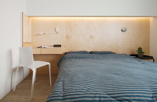 Góc đặt giường ngủ gọn gàng và ấm cúng với ánh sáng LED màu vàng.