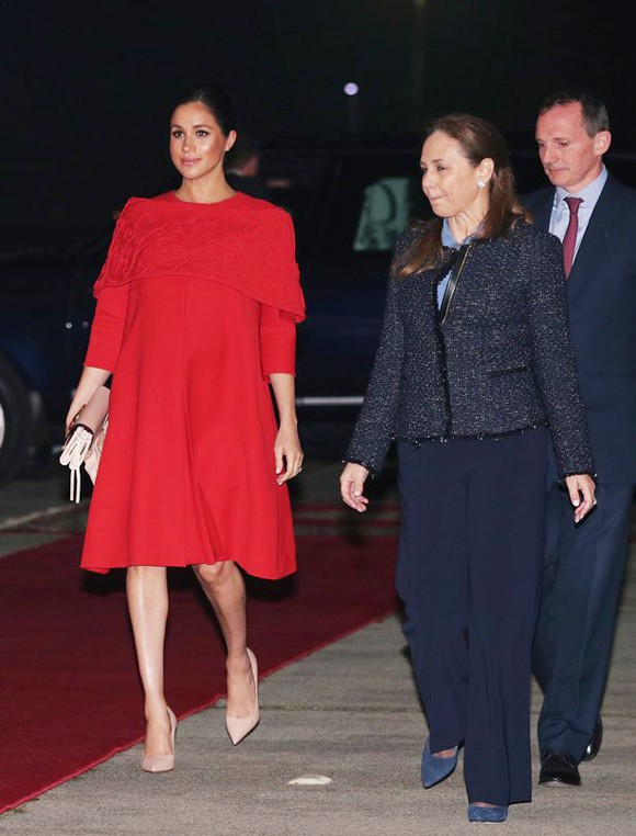 Meghan đi phía sau cùng các nhân viên trong khi Hoàng tử Harry bước nhanh phía trước khi tới sân bay Casablanca, Morocco tối 23/2. Ảnh: PA.