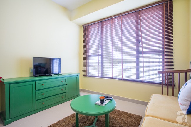 Góc tiếp khách đẹp nền nã với ghế khung gỗ thêm nệm màu vàng. Kệ ti vi cùng tông màu với bàn trà tạo sự liên kết tinh tế và hài hòa.