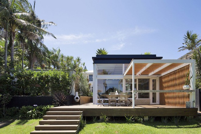 Phía đối diện với sofa được bố trí gọn gàng. Bức tường bằng gạch làm nổi bật màu sắc của ti vi và kệ đựng đồ. Phần sàn giật cấp giúp ngôi nhà như tôn cao hơn. Đây cũng là cách tăng thêm chức năng cho mọi người sử dụng mà không cần nhờ cậy đến tường phân cách.