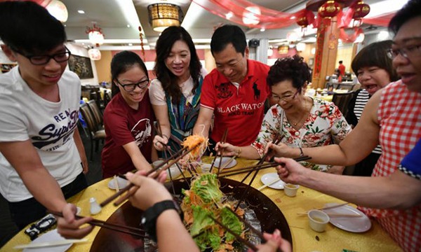 Siah Choo Ing (áo hoa, thứ ba từ phải sang) dùng bữa tất niên cùng gia đình tại nhà hàng hải sản ở Singapore. Ảnh: ST.
