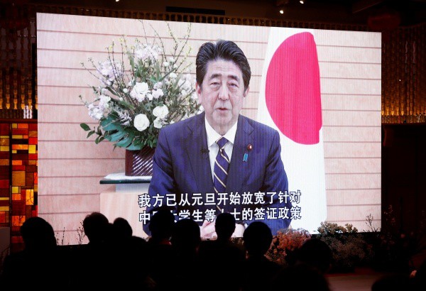 Người dân theo dõi thông điệp mừng năm mới Kỷ Hợi của Thủ tướng Nhật Bản Shinzo Abe tại Tháp Tokyo tối 4/2. Ảnh: Reuters.