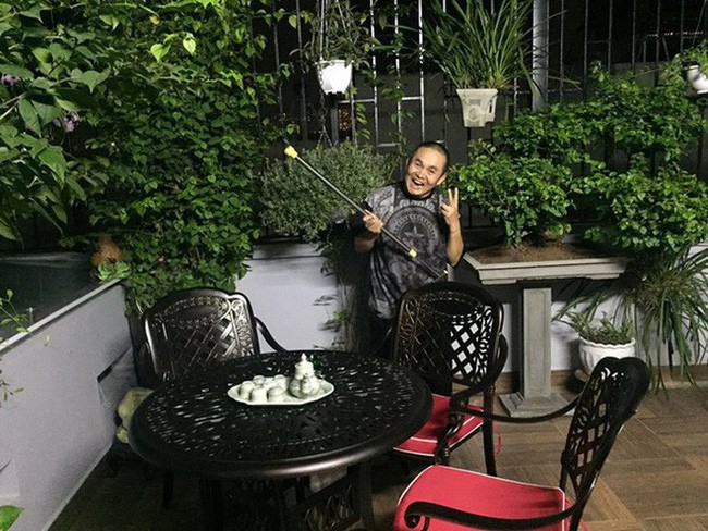 Xuân Hinh vui vẻ chăm sóc những giỏ cây xanh được treo trên tầng thượng