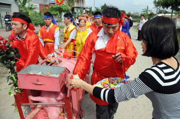 Đoàn tế rước di chuyển hai “ông ỉn” xung quanh làng để người dân được nhìn ngắm “ông ỉn” và lấy may trong năm mới.