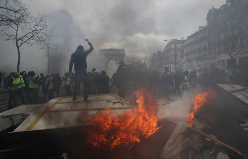 Người biểu tình áo vàng đốt phá tại Khải Hoàn Môn, Paris hôm 16/3. Ảnh: Reuters.