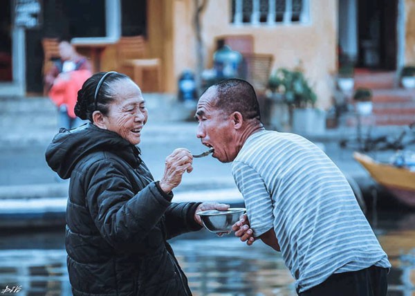 Bấy lâu nay người dân Hội An đã quen với hình ảnh này. Người mẹ đã già đang cười nheo đuôi mắt, đút cơm cho người con trai cũng đã lớn tuổi của mình ăn. Khoảnh khắc đấy, tuy bình dị nhưng thiêng liêng đến lạ, như thể không gian và thời gian xung quanh đều ngưng đọng lại, kính cẩn cúi mình trước pho tượng đài về mẹ, một pho tượng đài biết dãi nắng dầm sương, biết cười nheo đuôi mắt.