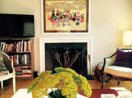 Phòng khách với hoa thơm, lò sưởi nằm trong tông màu ấm.