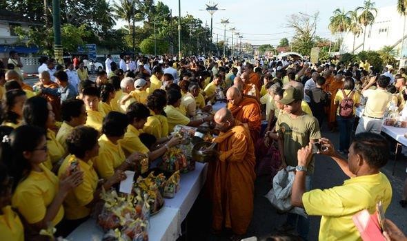 Người dân địa phương bố thí cho các nhà sư Phật giáo để chúc mừng sinh nhật lần thứ 66 của tân vương Maha Vajirusongkorn. Ảnh: Getty.