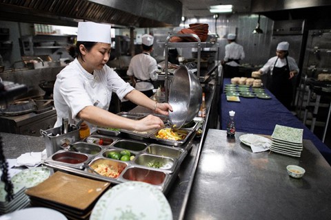 Các đầu bếp chuẩn bị thức ăn bên trong bếp của khách sạn Metropole Hà Nội. Ảnh: AFP.