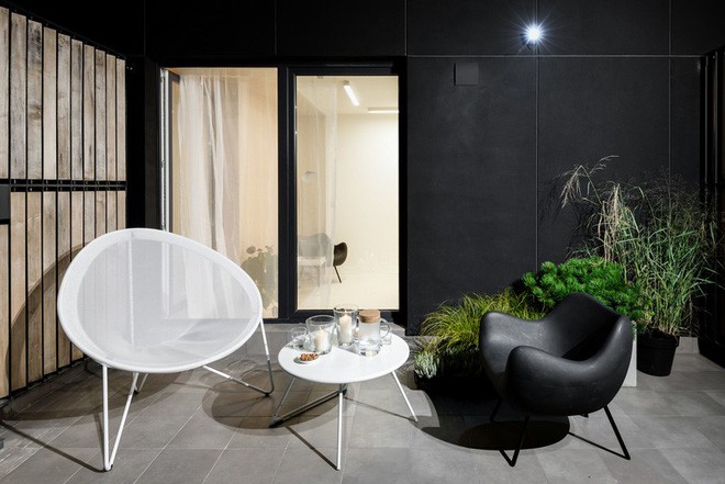 Ngoài ra ngôi nhà còn có phía hiên khá rộng, ở đây chủ nhân bố trí hai ghế bành trắng đen cách điệu khá hút mắt và một bàn tròn nhỏ uống nước.