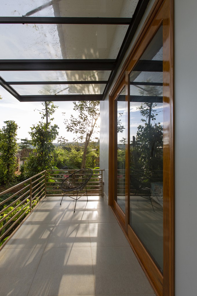 Mái hiên lắp kính vươn ra ngoài 2m, chống mưa tạt đồng thời vẫn đảm bảo đủ ánh sáng tự nhiên vào trong nhà. Mái hiên kính, cửa kính, hệ lam... những chi tiết nhỏ đều góp phần giúp ngôi nhà sáng sủa vào ban ngày.