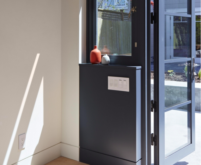 Khung cửa nối liền từ phía sau ra ngoài được thiết kế bằng gỗ sơn màu tím than tăng thêm sự tương phản ấn tượng giữa màu sơn trong nhà và màu bên ngoài.